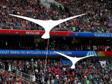 Воздушные змеи белого цвета в форме птиц на фоне трибун со зрителями с надписями FIFA 2018