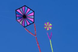 Два воздушных змев шестигранной формы с геометрическими рисунками на фоне голубого неба