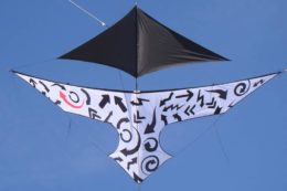 Воздушный змей с абстрактным черно-белым рисунком на фоне голубого неба